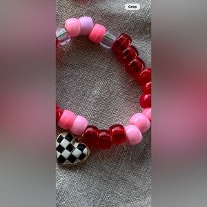 Valentine bracelet with pink red and clear beads and black and white heart.